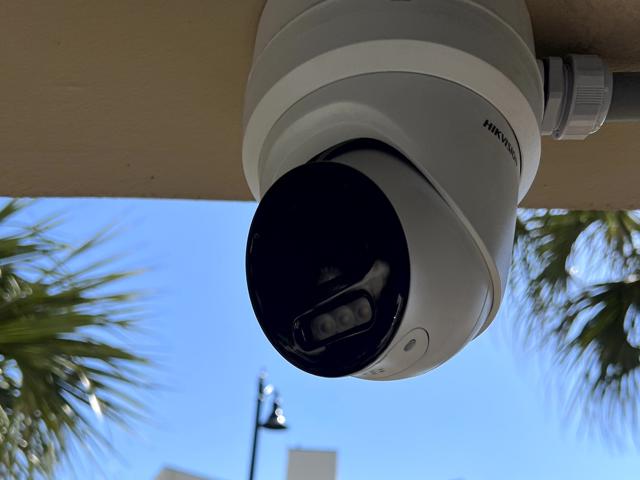 Beachfront security system installation with dual cameras overlooking a scenic ocean view.